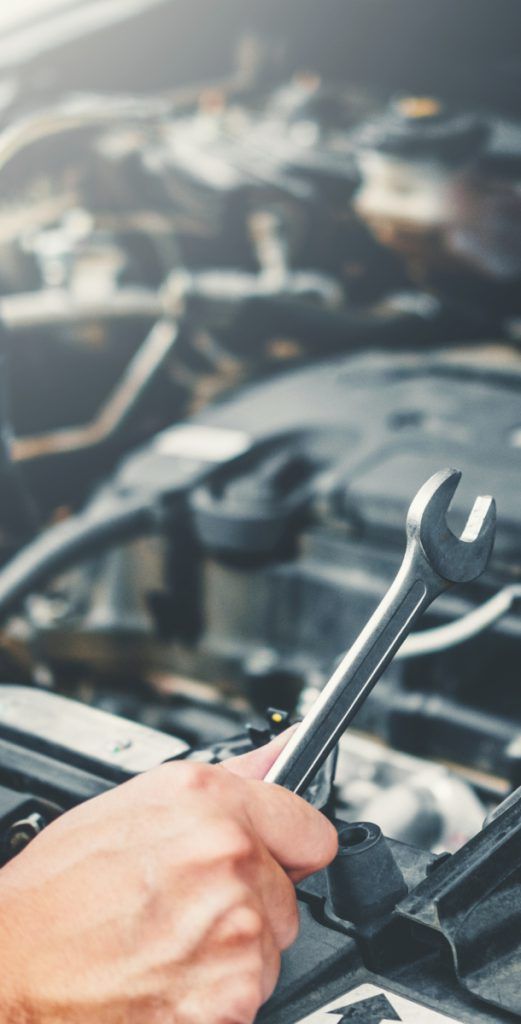 Auto Mechanic holding a spanner working over an engine - Car Repairs Liverpool